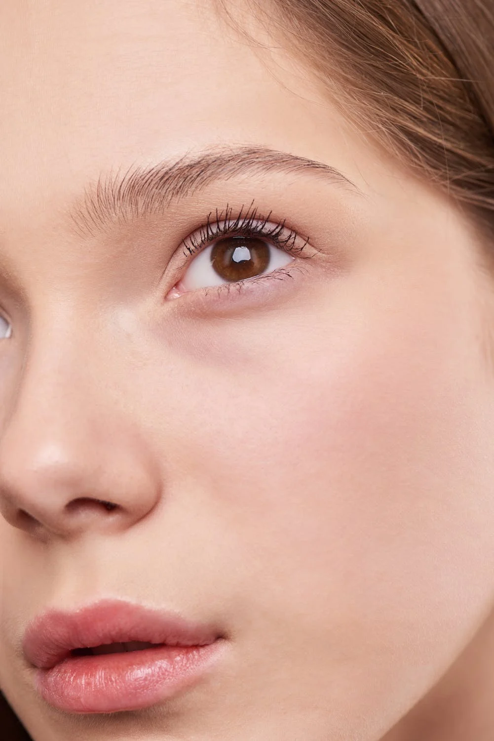 A woman with flawless, tight facial skin photographed up close.