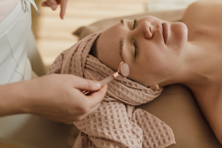 Person using a facial roller on woman's face